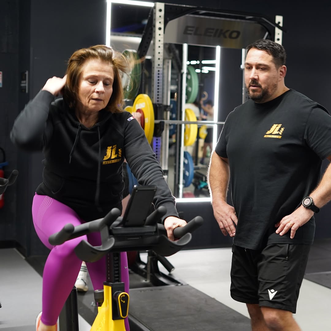 Coaching d'une cliente sur vélo en salle