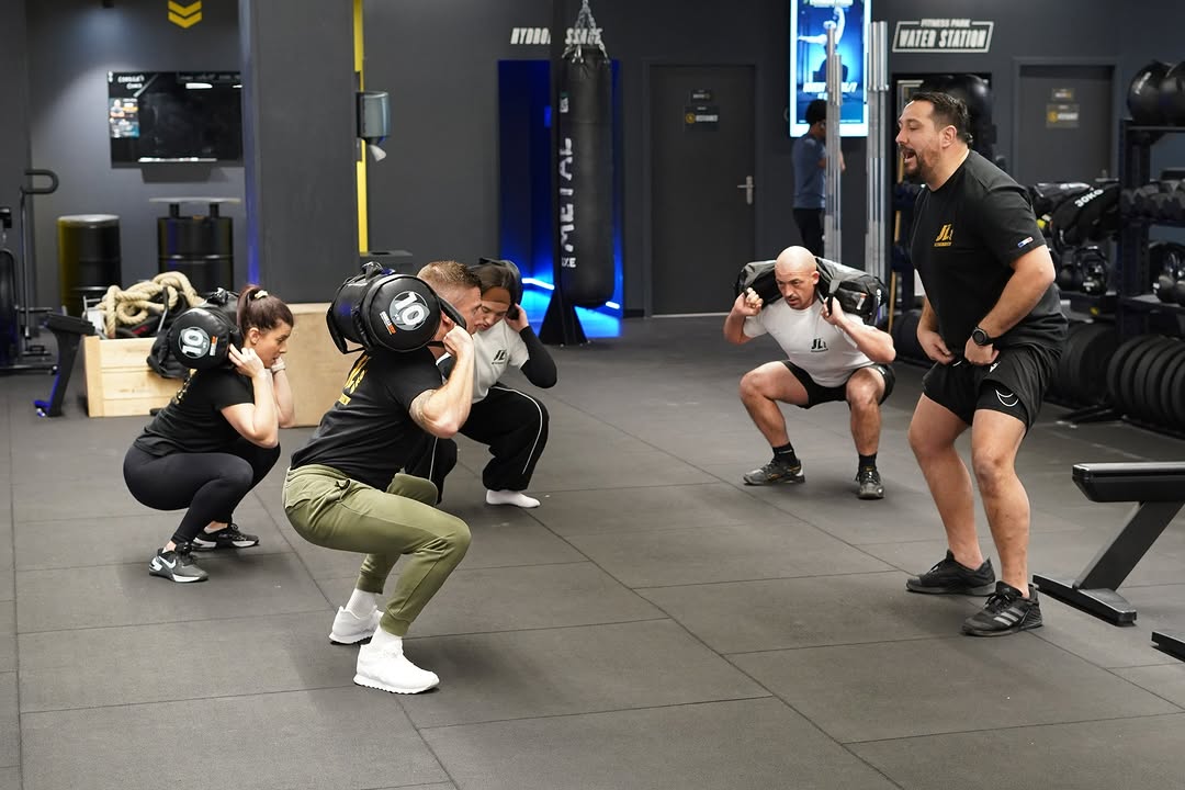 Séance de groupe, squats avec sac lesté